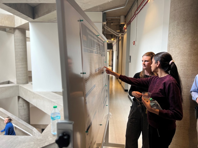 Emma Luhmann and Ishita Chandel discuss a poster.